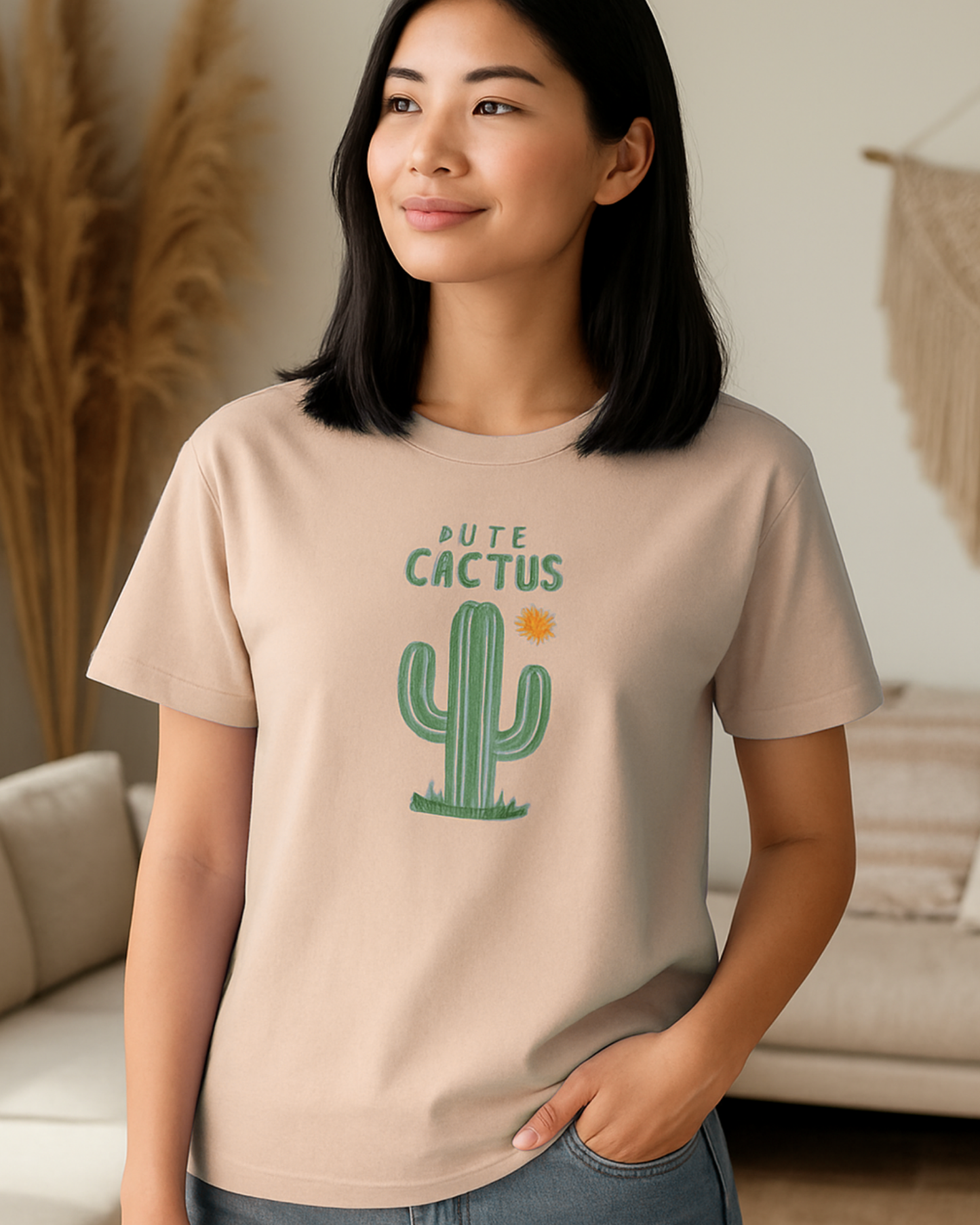 Woman wearing a peach t-shirt with a cactus graphic and text in a living room.