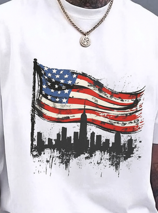 White oversized T-shirt featuring a bold American flag graphic with a New York City skyline design, modern streetwear style for men.