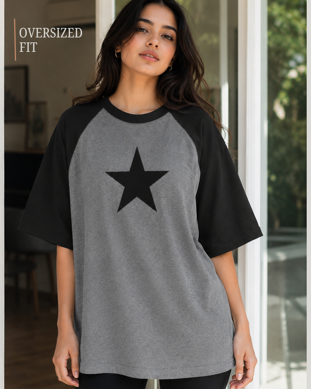 Female model wearing a black and white oversized raglan T-shirt with half sleeves and black star print.