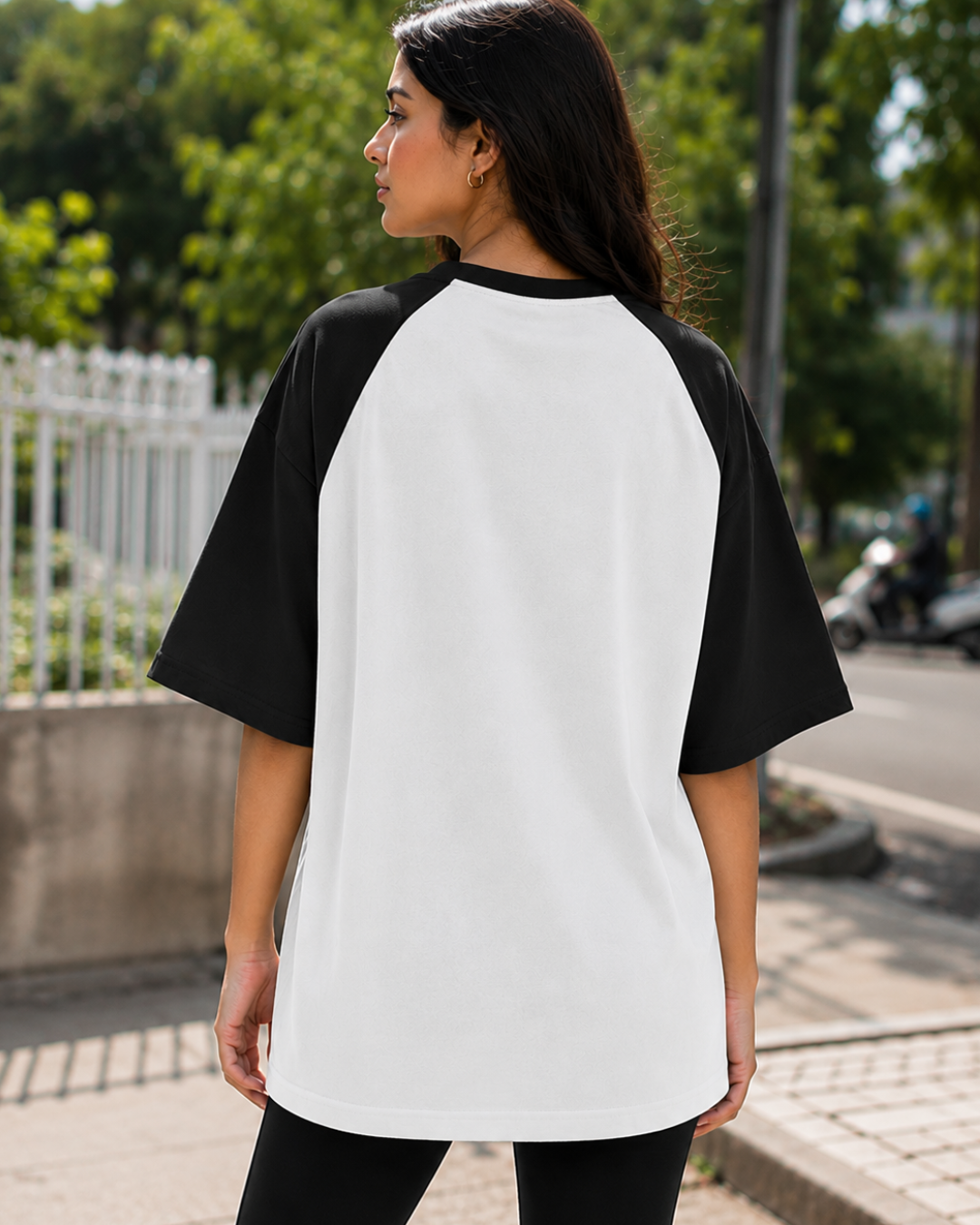 Female model wearing a black and white oversized raglan T-shirt with half sleeves and black star print