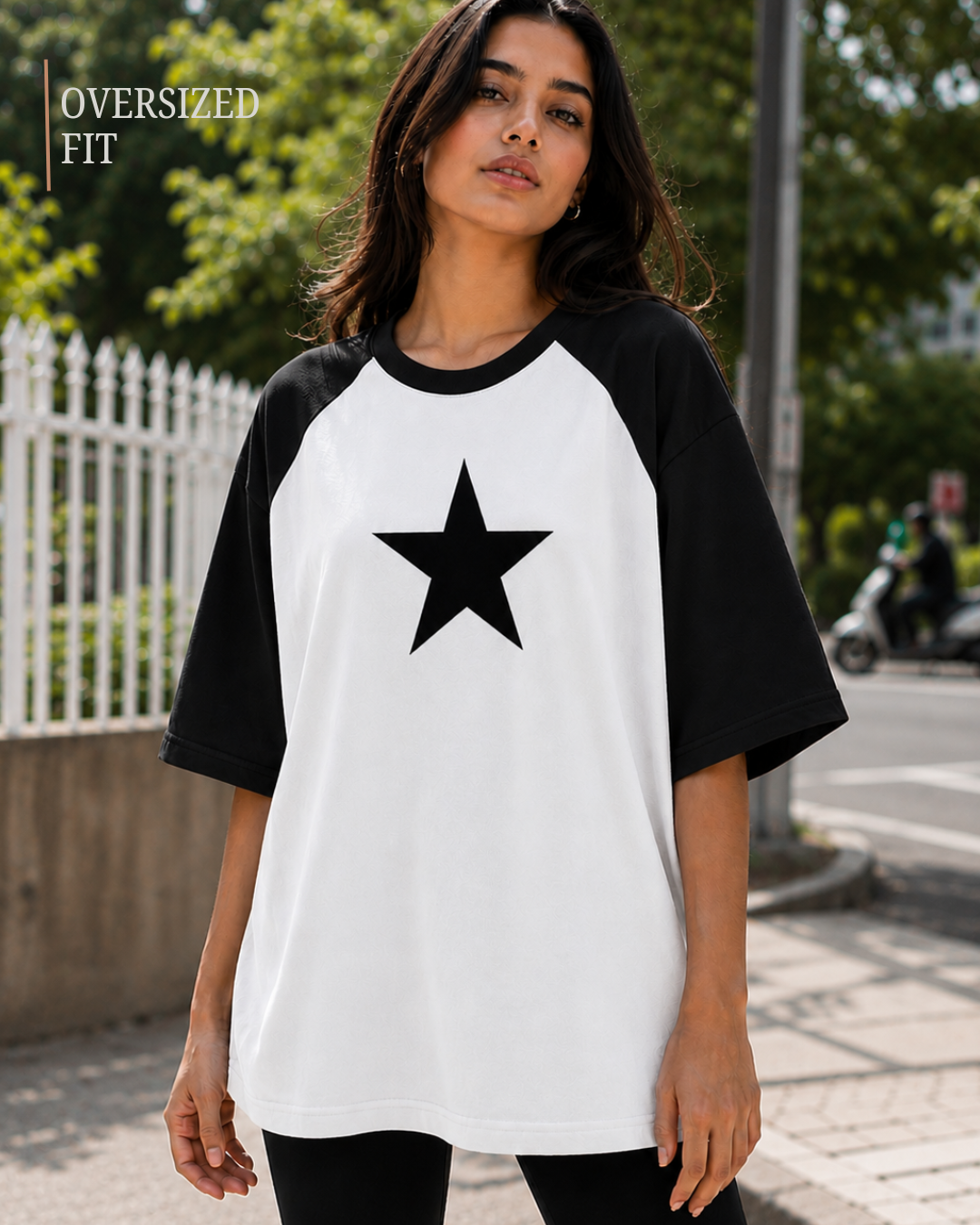 Female model wearing a black and white oversized raglan T-shirt with half sleeves and black star print