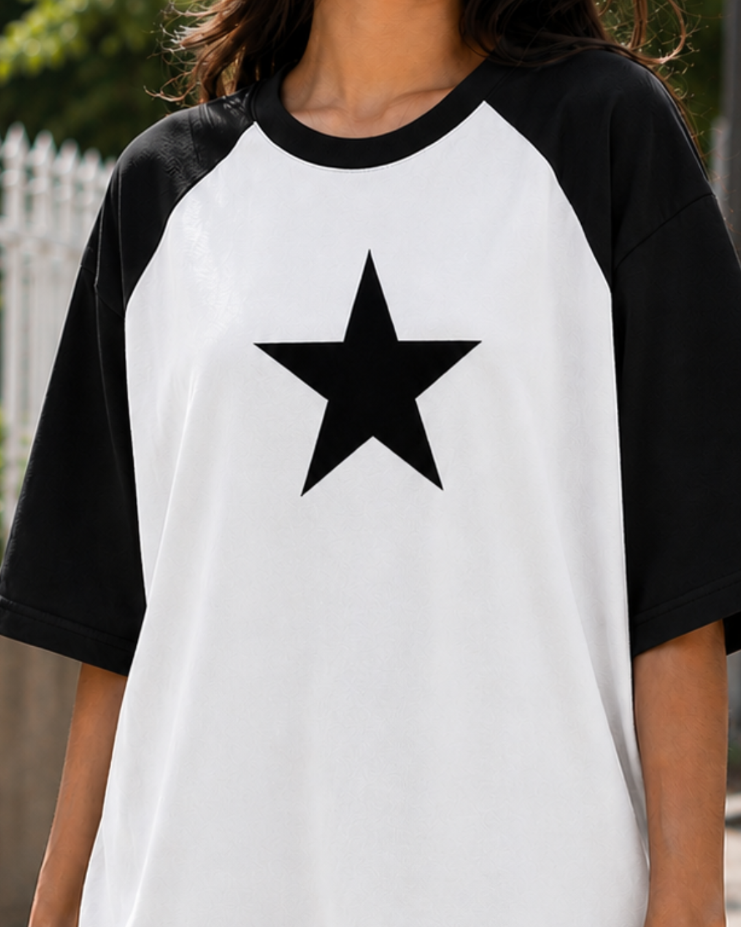 Female model wearing a black and white oversized raglan T-shirt with half sleeves and black star print