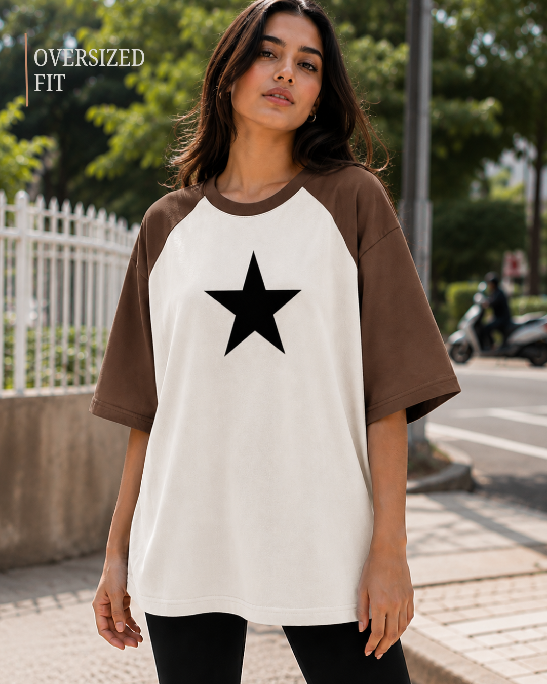 Female model wearing a black and white oversized raglan T-shirt with half sleeves and black star print