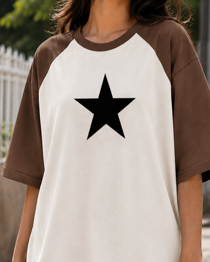 Female model wearing a black and white oversized raglan T-shirt with half sleeves and black star print