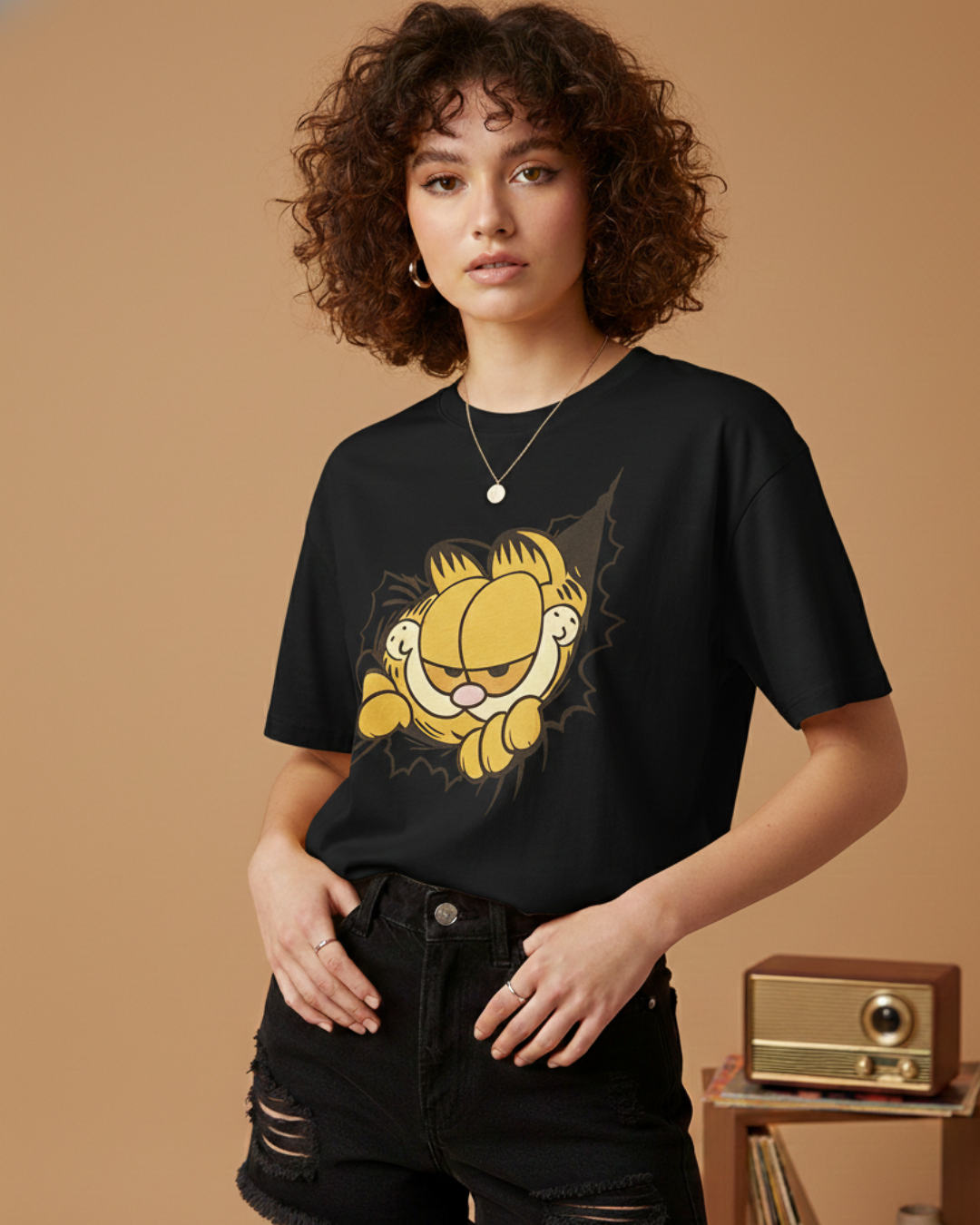 Person wearing a black t-shirt with a Garfield graphic on a brown background
