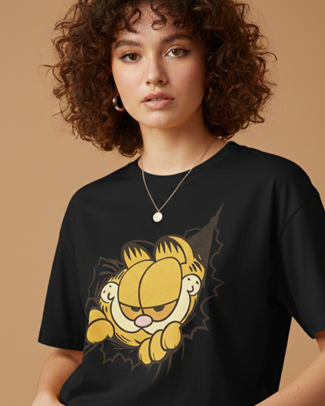 Person wearing a black t-shirt with a Garfield graphic on a beige background
