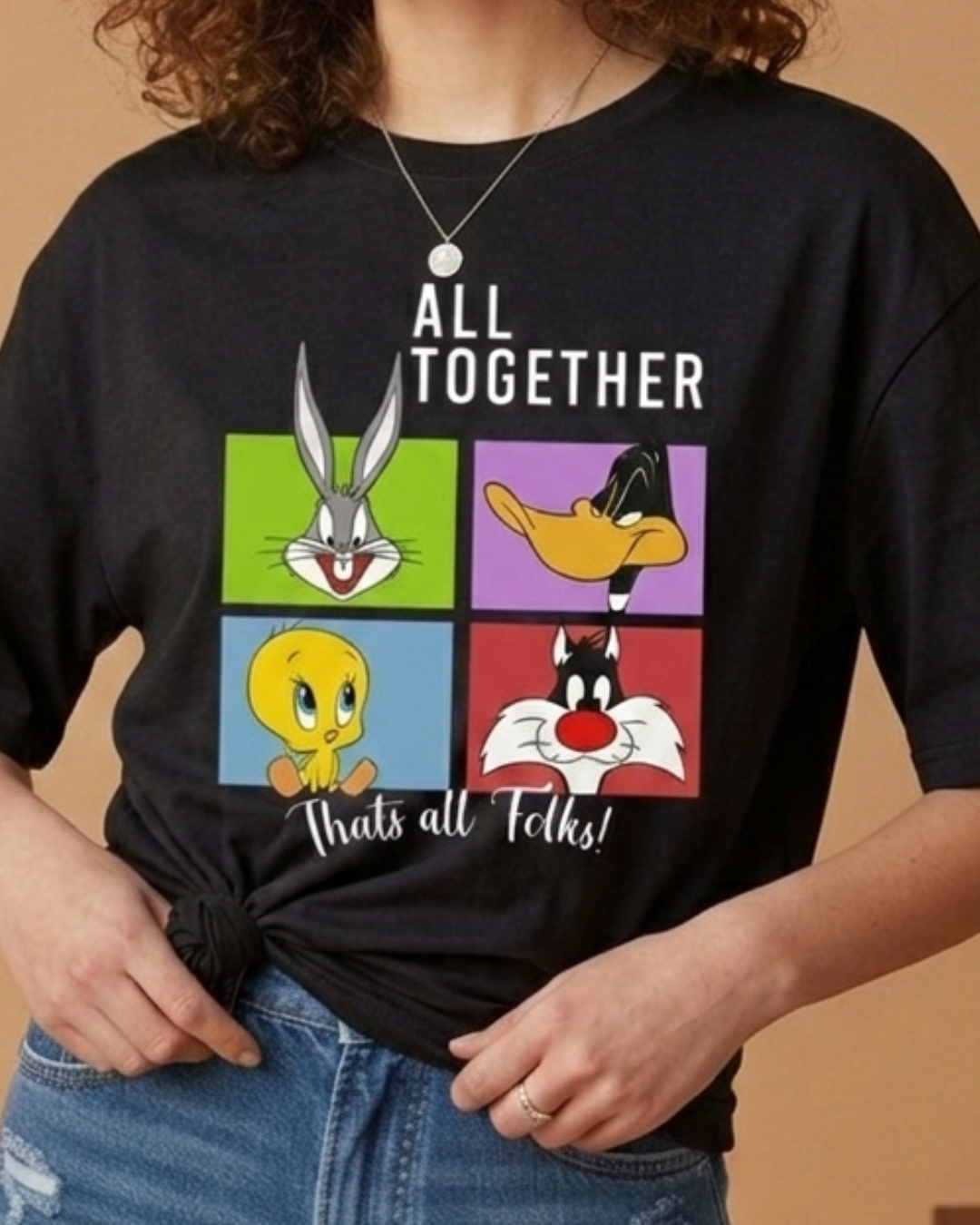 Person wearing a black t-shirt with Looney Tunes characters and text.
