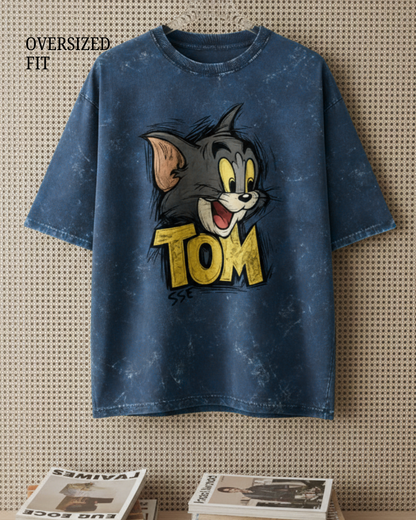 Blue t-shirt with cartoon character and 'TOM' text on a textured wall background