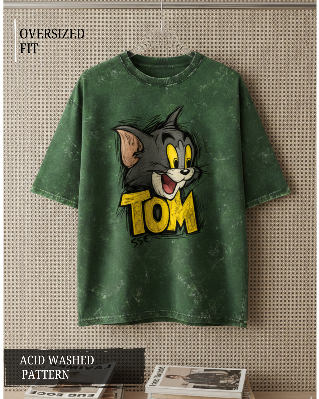 Green acid-washed t-shirt with cartoon character and 'Tom' text on a textured surface.