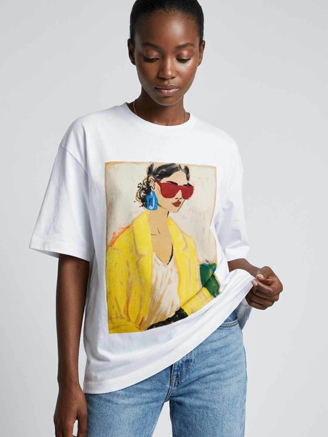 Person wearing a white t-shirt with a colorful graphic design on a plain background
