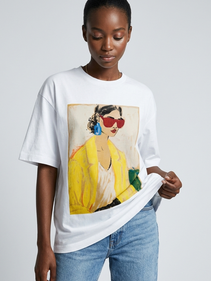 Person wearing a white t-shirt with a colorful graphic design on a plain background