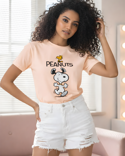 Woman wearing a 'Peanuts' t-shirt with Snoopy and Woodstock, standing in a room.