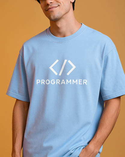 Person wearing a light blue t-shirt with 'PROGRAMMER' text and symbols on a mustard yellow background