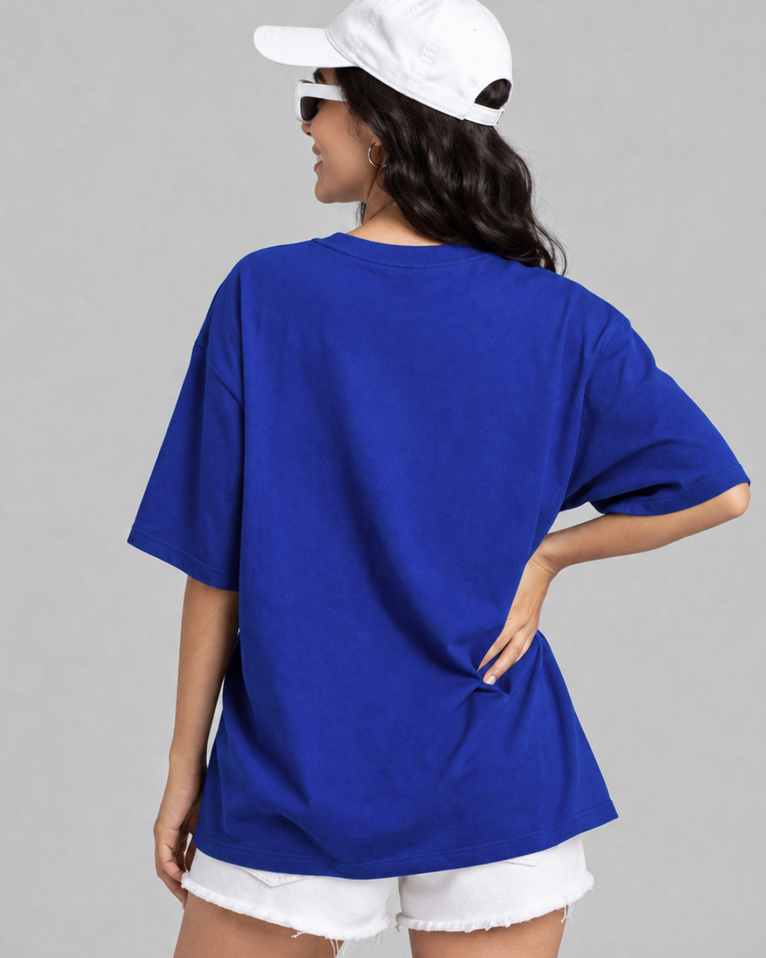 A woman shown from the back wearing an oversized royal blue short-sleeve t-shirt, white shorts from white bear brand