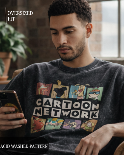 Man wearing a 'Cartoon Network' graphic t-shirt, holding a phone indoors.