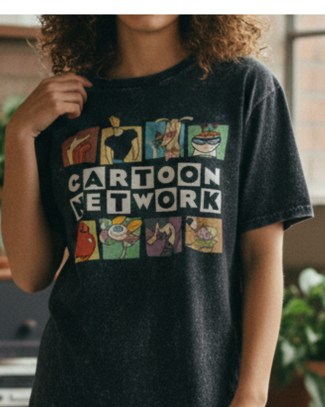 Person wearing a black 'Cartoon Network' t-shirt with colorful graphics.