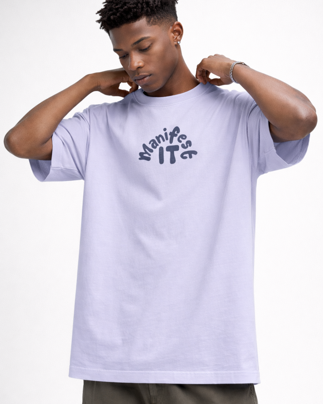 Person wearing a light purple t-shirt with 'Manifeste IT' text on a white background