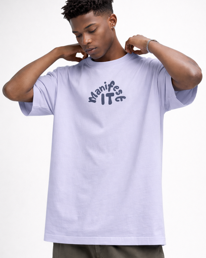 Person wearing a light purple t-shirt with 'Manifeste IT' text on a white background