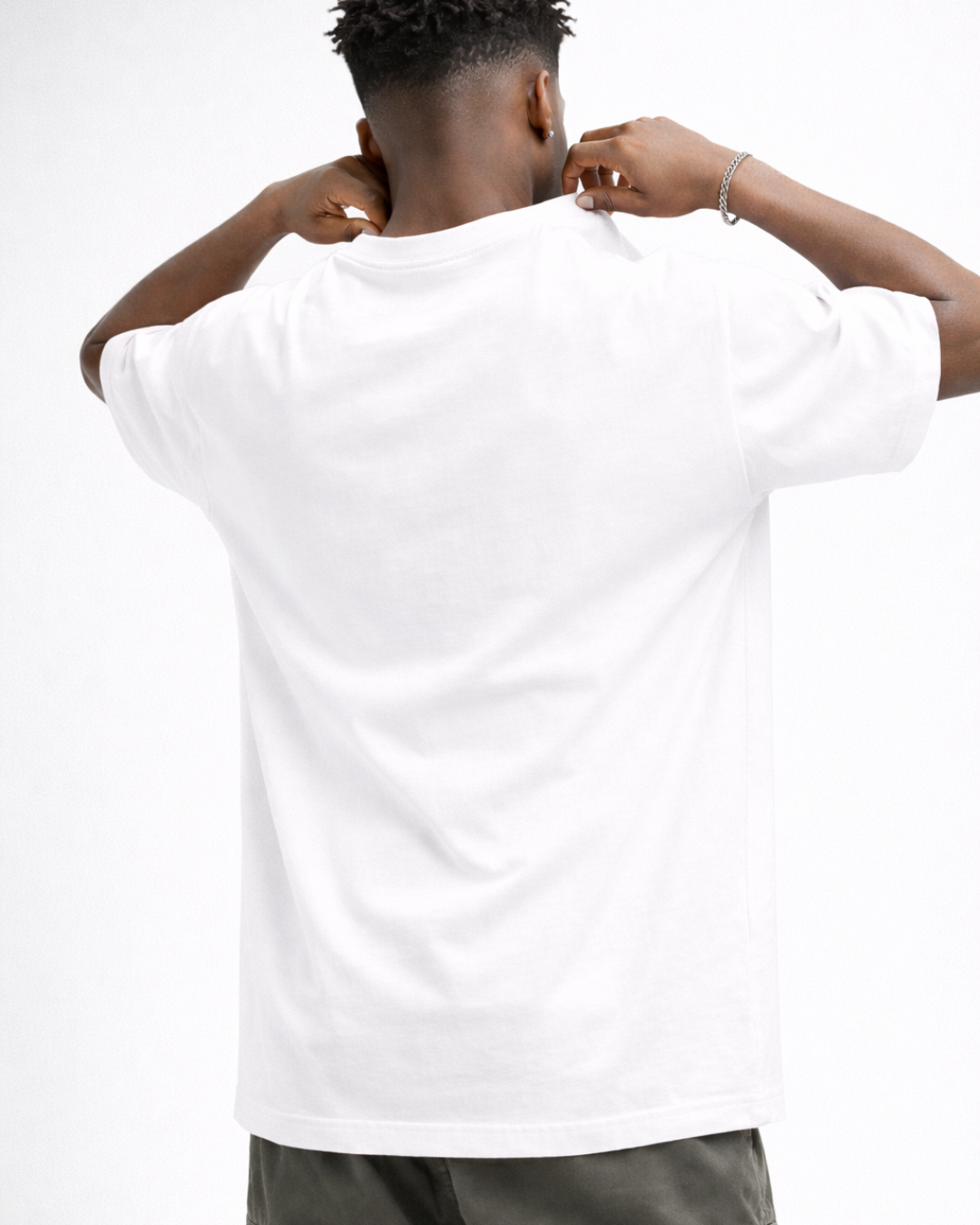 Person wearing a white t-shirt with arms behind head on a plain background