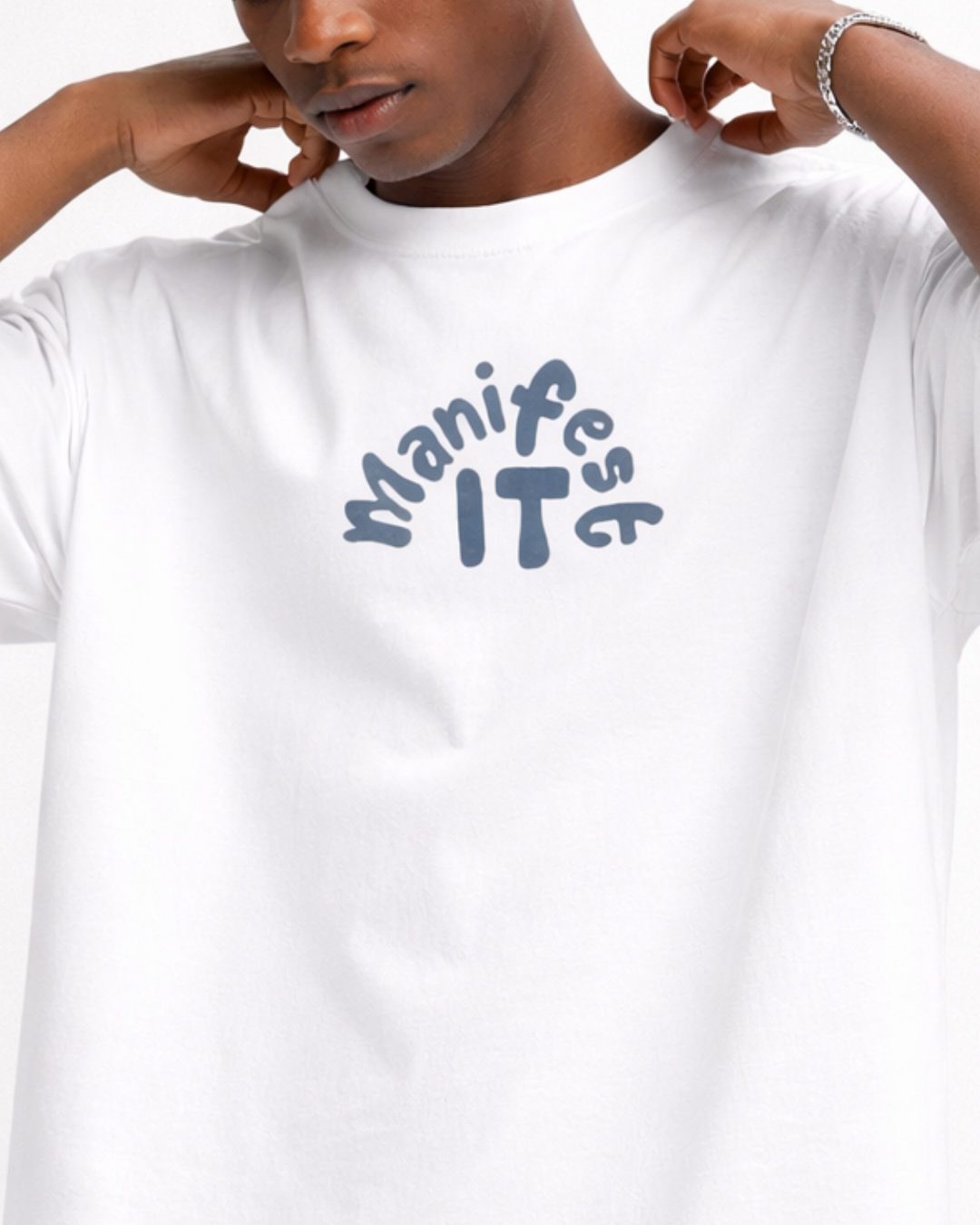 Person wearing a white t-shirt with 'Manifest IT' text in blue.