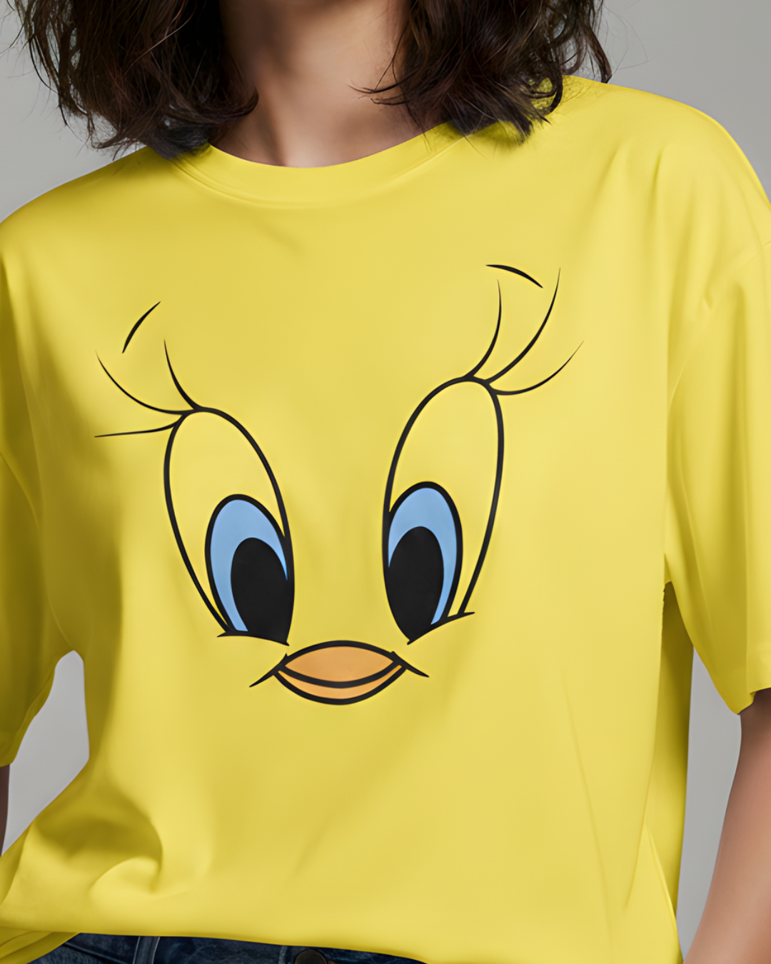 Yellow t-shirt with a cartoon face design on a plain background