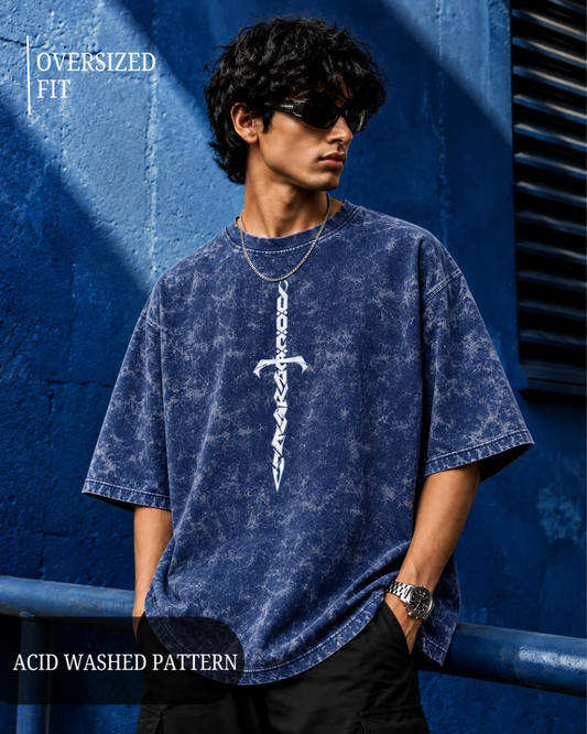 an oversized blue acid-washed t-shirt with a white vertical sword graphic, posed against a textured blue wall from white bear brand