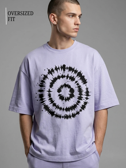 Man wearing a light purple t-shirt with a black spiral design on a gray background