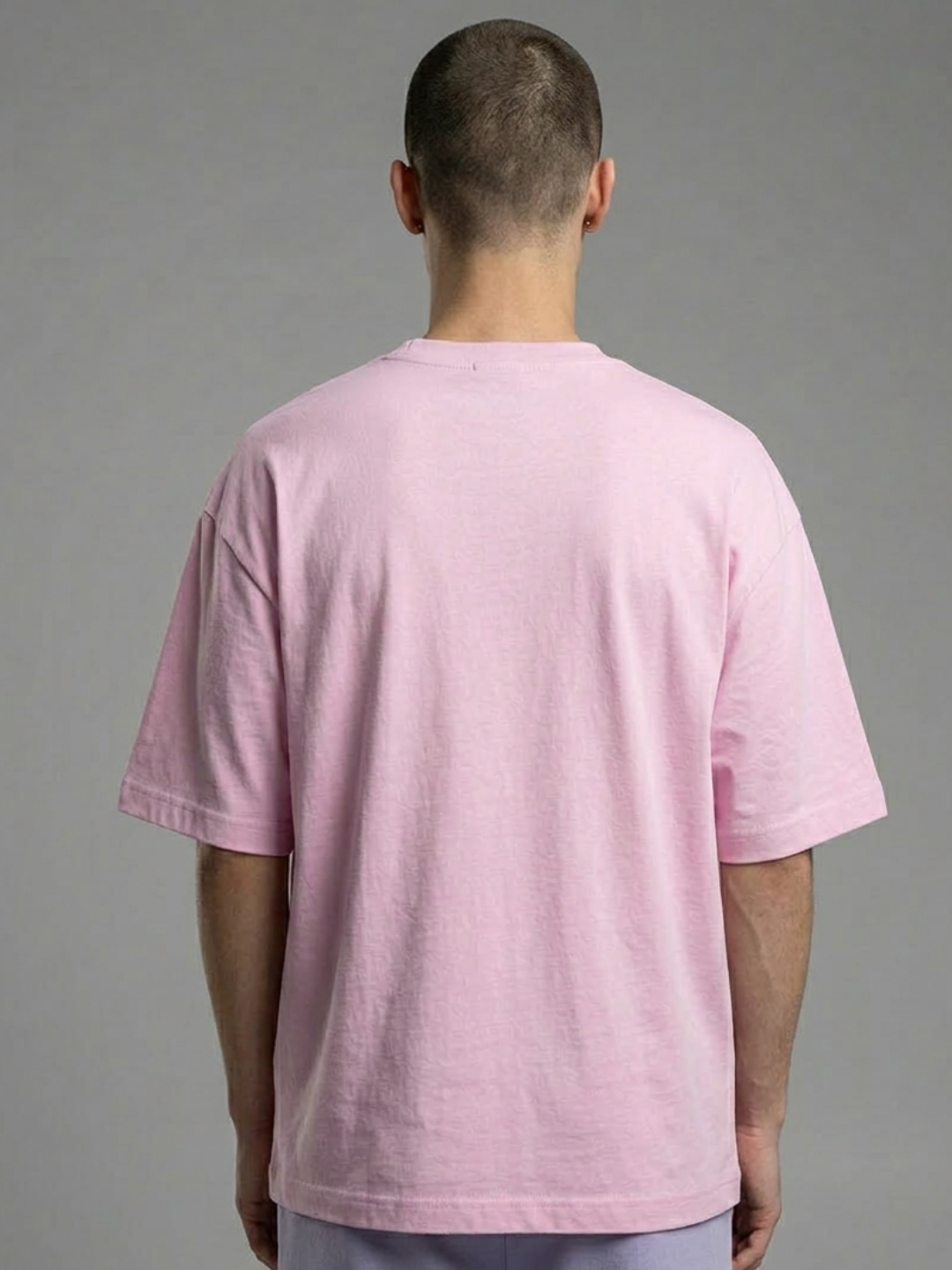 Person wearing a pink t-shirt against a gray background